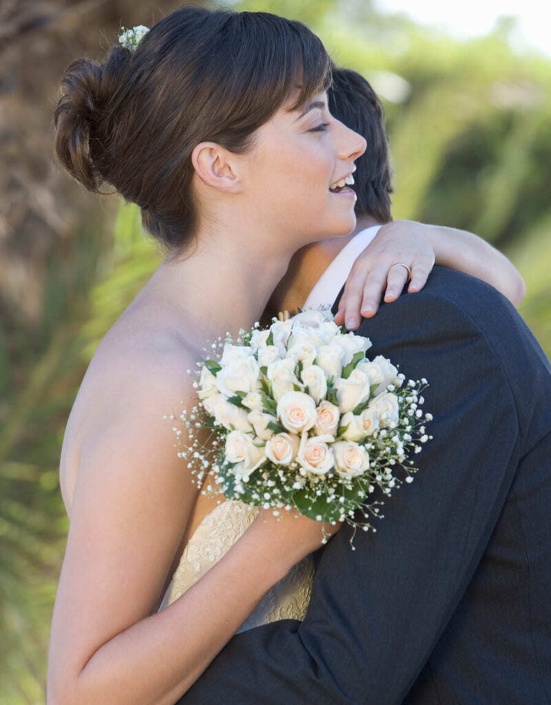 novio y novia sujetando ramo flores abrazados en su boda chapoo